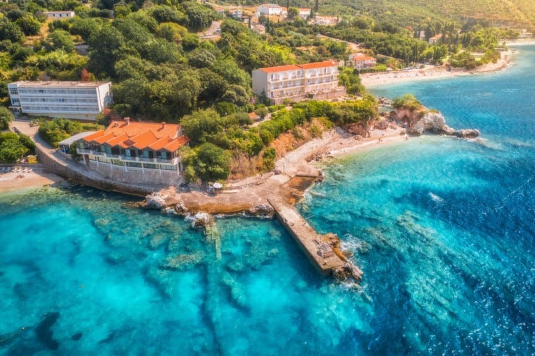 Aerial view with sea coast, sandy beach, blue water, hotels